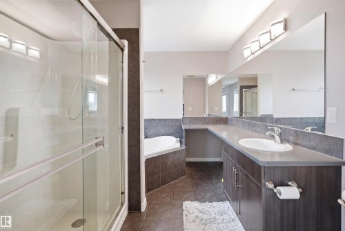 Walk-in shower with clear glass enclosure and white basin - 1444 37C Avenue, Edmonton, AB - Indoor Photo Showing Bathroom