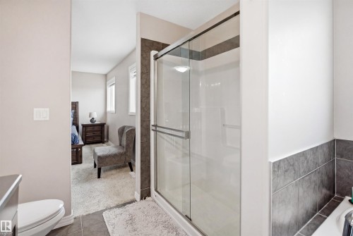 Glass-enclosed shower with a modern sliding door and recessed lighting - 1444 37C Avenue, Edmonton, AB - Indoor Photo Showing Bathroom