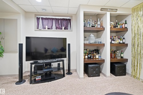 Built-in shelving with wood-finish surfaces, recessed lighting, and a textured carpeted floor - 1444 37C Avenue, Edmonton, AB - Indoor