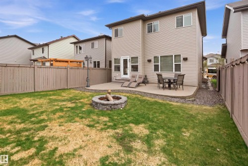 Private backyard featuring a stone-lined fire pit, concrete patio, and full perimeter fencing - 1444 37C Avenue, Edmonton, AB - Outdoor With Deck Patio Veranda With Exterior