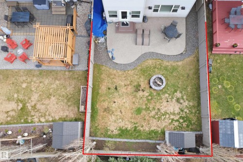 Expansive backyard featuring a concrete patio, gravel pathway, and a central fire pit - 1444 37C Avenue, Edmonton, AB - 