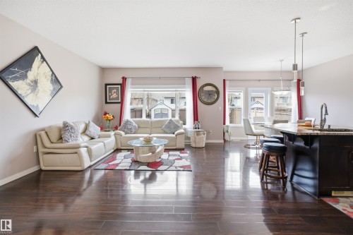 Spacious living area featuring wood-finish flooring, ample natural light from multiple windows, and recessed lighting - 1444 37C Avenue, Edmonton, AB - Indoor Photo Showing Living Room