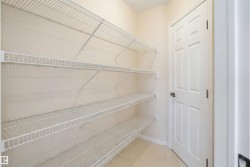 Interior storage area featuring light-colored walls and multiple levels of wire shelving - 