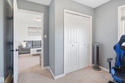 Light-colored carpeting throughout, with crisp white baseboards and neutral gray wall paint - 