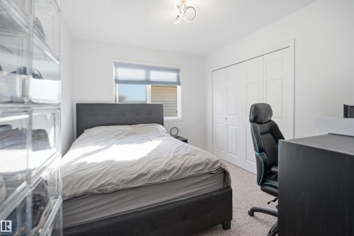 Bedroom featuring a window with roller shades, white walls, and light-colored carpet flooring - 1453 Hays Way, Edmonton, AB - Indoor Photo Showing Bedroom