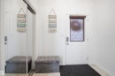 White entry door with decorative glass panel, ceramic tile flooring, and sliding mirrored closet doors - 1453 Hays Way, Edmonton, AB  - Indoor Photo Showing Other Room 