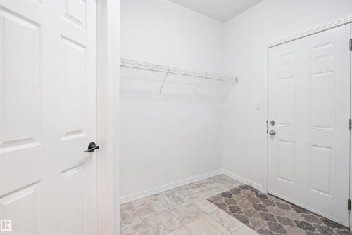 Entryway featuring a white paneled door, black hardware, and wire shelving - 1453 Hays Way, Edmonton, AB - Indoor