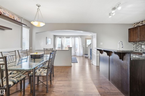 Dining area featuring wood-finish flooring and a contemporary pendant light fixture - 1144 35 Avenue, Edmonton, AB - Indoor Photo Showing Dining Room