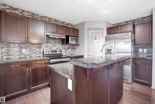 Kitchen featuring a central island with an integrated sink and gooseneck faucet - 1144 35 Avenue, Edmonton, AB - Indoor Photo Showing Kitchen With Upgraded Kitchen