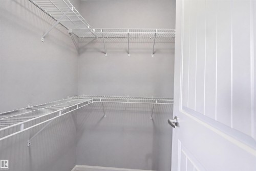 Walk-in closet with multi-level wire shelving, gray painted walls, and white trim - 1144 35 Avenue, Edmonton, AB - Indoor With Storage