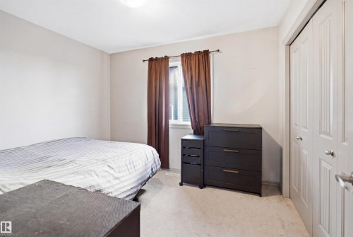 Carpeted room featuring a window with blinds, a bi-fold closet, and a flush mount ceiling light fixture - 1144 35 Avenue, Edmonton, AB - Indoor Photo Showing Bedroom