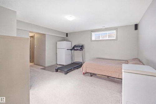 Carpeted room featuring a single window with blinds, a flush-mount ceiling light, and light gray painted walls - 1144 35 Avenue, Edmonton, AB - Indoor