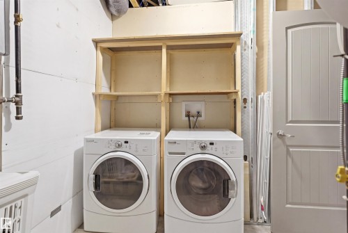 Functional utility area featuring a light wood-finish shelving unit, white paneling, and a light gray six-panel door - 1144 35 Avenue, Edmonton, AB - Indoor Photo Showing Laundry Room