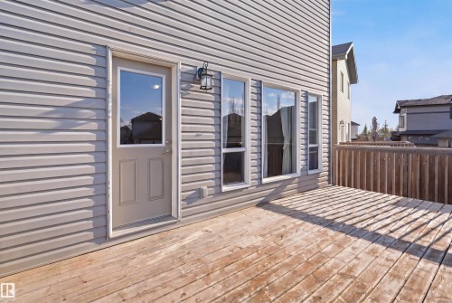 Spacious outdoor deck featuring natural wood planks, a wooden perimeter fence, and light gray vinyl siding - 1144 35 Avenue, Edmonton, AB - Outdoor With Deck Patio Veranda With Exterior