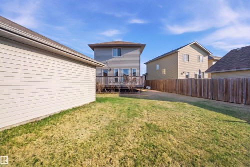 Expansive backyard featuring a manicured lawn, a full wood privacy fence, and a detached garage with neutral-toned siding - 1144 35 Avenue, Edmonton, AB - Outdoor With Deck Patio Veranda With Exterior