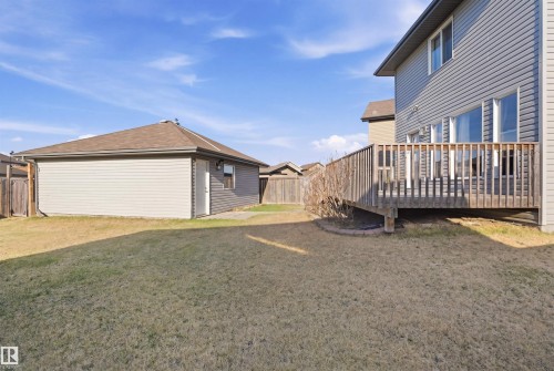 Expansive backyard featuring a wood-finish deck, detached garage, and perimeter fencing - 1144 35 Avenue, Edmonton, AB - Outdoor With Exterior