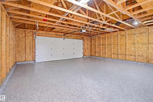 Spacious garage featuring an epoxy-coated concrete floor and exposed wood framing - 1144 35 Avenue, Edmonton, AB - Indoor Photo Showing Garage