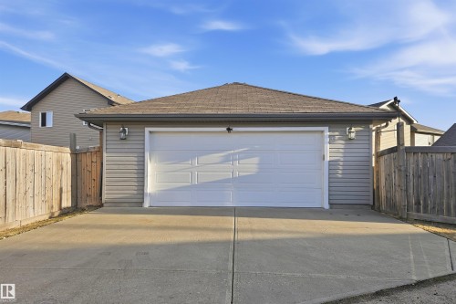 Detached garage with a single white panel door and durable shingle roofing - 1144 35 Avenue, Edmonton, AB - Outdoor