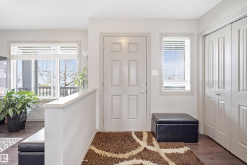Entryway featuring wood-finish flooring, a paneled entry door, and a white half-wall - 1144 35 Avenue, Edmonton, AB - Indoor Photo Showing Other Room