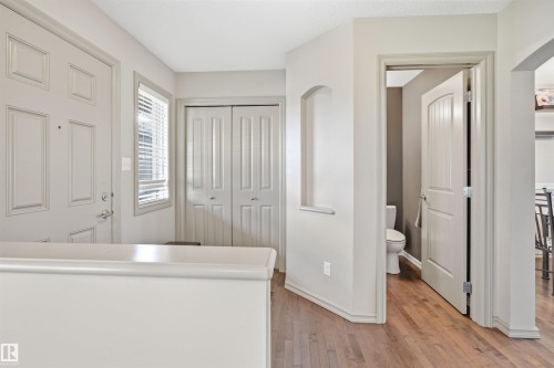 Entryway featuring wood-finish flooring, a paneled entry door, window with blinds, and a double bi-fold closet - 1144 35 Avenue, Edmonton, AB - Indoor Photo Showing Other Room