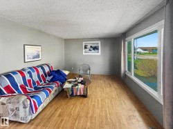 Spacious room featuring light wood-finish flooring, neutral gray walls, and white trim - 