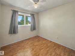 Interior space featuring wood-finish flooring, a double window, and a ceiling fan with integrated lighting - 