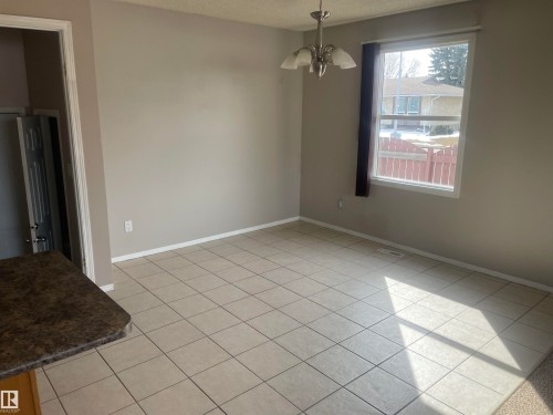 The property features a bright room with tiled flooring and a window providing natural light - 2629 129A Avenue, Edmonton, AB - Indoor Photo Showing Other Room