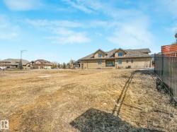 Expansive undeveloped lot featuring a black metal fence along one boundary - 