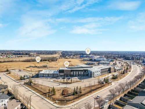 Aerial perspective showcasing a commercial building with a grey and brown facade, surrounded by paved parking areas - 2794 Wheaton Drive, Edmonton, AB 