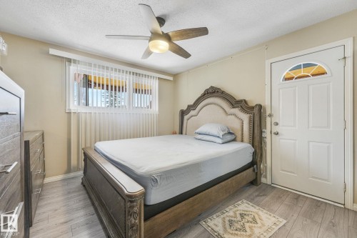 Interior room featuring wood-finish flooring, a ceiling fan with integrated lighting, and a window with vertical blinds - 2 Scarboro Place, St. Albert, AB - Indoor Photo Showing Bedroom