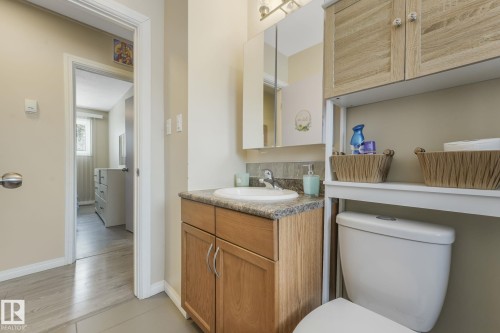 Bathroom vanity with wood-finish cabinetry, a granite-look countertop, and a white integrated sink - 2 Scarboro Place, St. Albert, AB - Indoor Photo Showing Bathroom