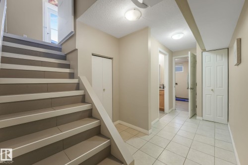 Staircase with contrasting risers and treads, complemented by a white banister and light-colored walls - 2 Scarboro Place, St. Albert, AB - Indoor Photo Showing Other Room
