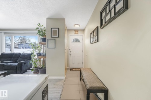 Entryway featuring a white paneled door with an arched glass insert, tile flooring, and neutral wall tones - 2 Scarboro Place, St. Albert, AB - Indoor