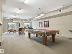 Spacious recreation room featuring a billiards table, carpeted flooring, and recessed lighting - 