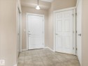 Entryway featuring tiled flooring, three white paneled doors, and light neutral wall paint - 417 612 111 Street, Edmonton, AB  - Indoor Photo Showing Other Room 