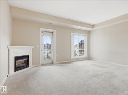 Corner-mounted fireplace with a white mantel, light-colored carpeting, two windows with white trim, and a door leading to an exterior balcony - 