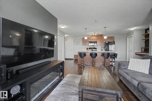 Open-concept living space featuring wood-finish flooring throughout - 334 504 Albany Way, Edmonton, AB - Indoor Photo Showing Living Room