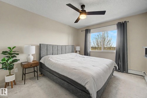 Inviting room with light-toned walls, plush carpeting, and a modern ceiling fan with integrated lighting - 334 504 Albany Way, Edmonton, AB - Indoor Photo Showing Bedroom