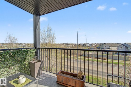 Outdoor balcony featuring black metal railings and a textured overhead soffit - 334 504 Albany Way, Edmonton, AB - Outdoor With Exterior