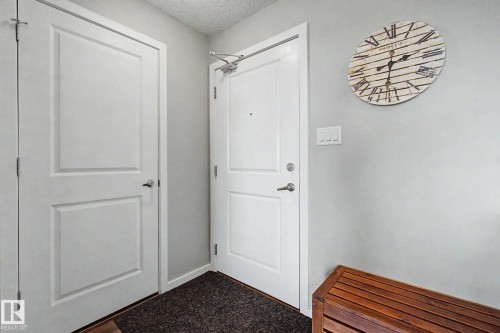 Entryway featuring two paneled doors, light gray wall paint, and a dark textured floor mat - 334 504 Albany Way, Edmonton, AB - Indoor Photo Showing Other Room