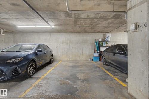 Concrete parking garage with two marked parking spaces - 334 504 Albany Way, Edmonton, AB - Indoor Photo Showing Garage