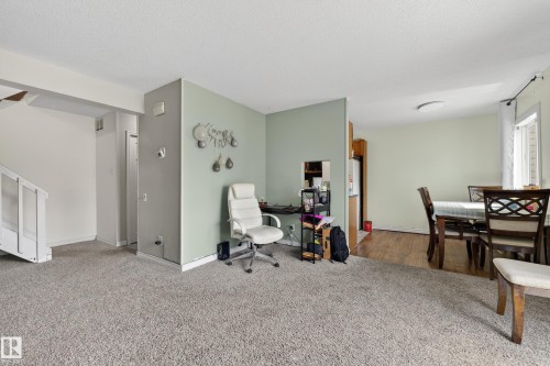 Open-concept living area featuring light gray carpeting and a neutral wall palette - 26E Meadowlark Village, Edmonton, AB - Indoor