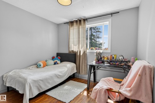 Room featuring a single window with white trim, wood-finish flooring, and light gray walls - 26E Meadowlark Village, Edmonton, AB - Indoor Photo Showing Bedroom