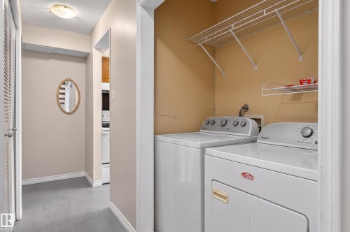Dedicated laundry area featuring a top-loading washer and front-loading dryer - 26E Meadowlark Village, Edmonton, AB - Indoor Photo Showing Laundry Room