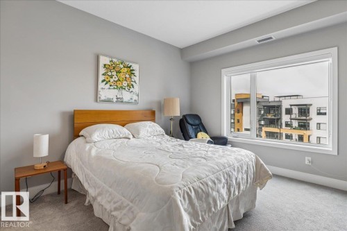 LARGE PRIMARY BEDROOM WITH SPACE FOR A KING BED. VIEWS OF THE RAVINE AND DOWNTOWN - 428 7463 May Common, Edmonton, AB - Indoor Photo Showing Bedroom