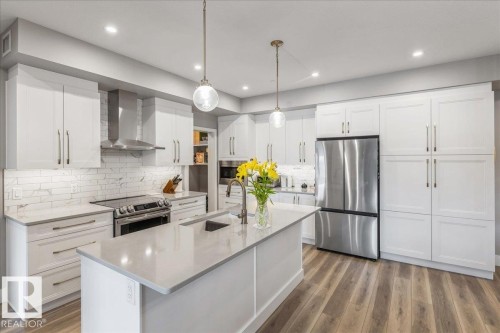 LARGE KITCHEN ISLAND WITH QUARTZ TOP AND SILGRANITE SINK - 428 7463 May Common, Edmonton, AB - Indoor Photo Showing Kitchen With Stainless Steel Kitchen With Upgraded Kitchen