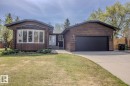 Wood-sided property featuring a concrete driveway and an attached single-bay garage with a black door - 3412 110 Street, Edmonton, AB  - Outdoor 