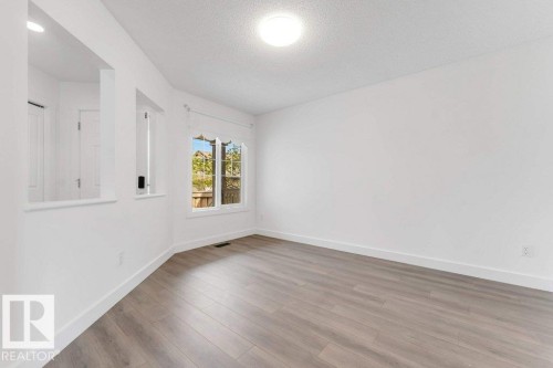 Open-concept room featuring light wood-finish flooring, white walls, and a recessed ceiling light - 7403 Singer Landing Landing, Edmonton, AB - Indoor Photo Showing Other Room