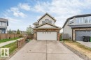 Two-story residential property featuring a white garage door, stone and siding exterior, and a concrete driveway - 7403 Singer Landing Landing, Edmonton, AB  - Outdoor 