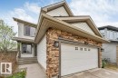 Two-story residence featuring a prominent attached garage with decorative window inserts - 7403 Singer Landing Landing, Edmonton, AB  - Outdoor With Exterior 